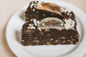 Geschnittener Schokoladenkuchen auf Keksen, mit Geleebananen-Topping