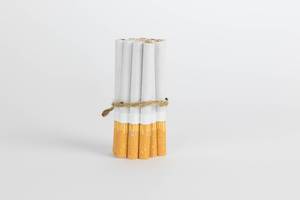 Geschnürte Zigaretten vor weißem Hintergrund