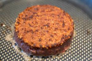 Gesunde Ernährung mit dem pflanzlichen Burger-Patty von Beyond Meat, in der Pfanne gebraten, für ein veganes Essen und Gluten und Soja