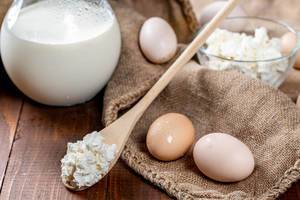 Gesunde Milchprodukte und Proteine – Milch, Hüttenkäse und Eier auf Jutesack