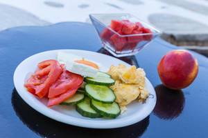 Gesunde Zwischenmahlzeit mit frischen Tomaten, Gurken, Fetakäse, Rührei und Wassermelone