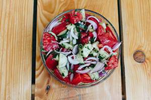 Gesunder Salat mit Tomate, Gurke und Zwiebel von oben fotografiert