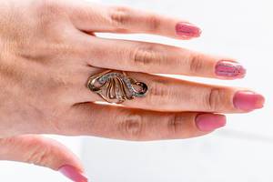 Gewschwungener Ring als Frauenschmuck an der Hand eines Mädchens