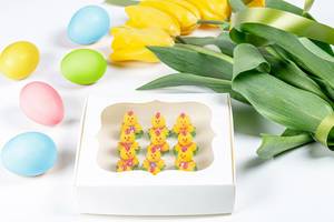 Gift box with a sweet dessert in the shape of chickens, colorful eggs and yellow tulips (Flip 2020)