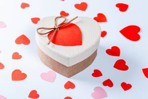 Gift box with red hearts on white background