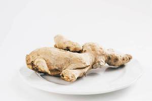 Ginger root in a plate on white background