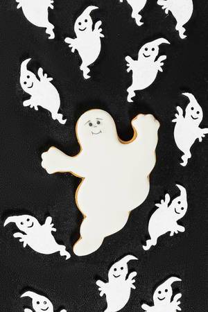 Gingerbread apparition and Halloween decor ghosts on black background