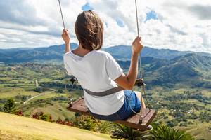 Girl on swing at the clouds in mountain Redonda at Dominican Republic