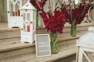 Gladiole-Blumen in einer Glasvase und dem Schild "Finally Married" (endlich verheiratet)