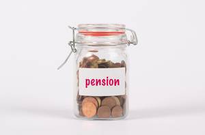 Glasgefäß als Sparschwein und der Aufschrift "Pension", besteht aus wenig Kleingeld