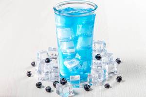 Glass of blue cocktail with ice and fresh blueberries (Flip 2019)
