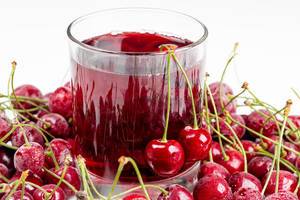 Glass of cherry juice with fresh cherry berries