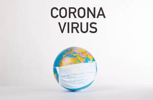 Globe with medical mask and Corona Virus text on white background