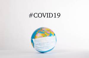 Globe with medical mask and #COVID19 text on white background.jpg
