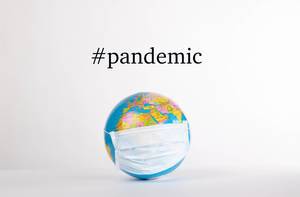 Globe with medical mask and #pandemic text on white background