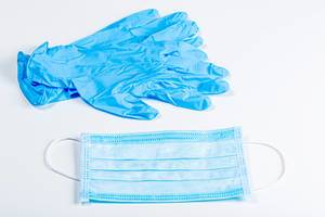 Gloves and disposable medical mask on a white background