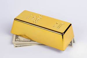 Gold bar on top of the money stack