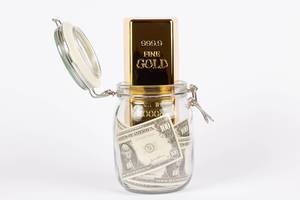 Goldbarren im Glasgefäß mit Geld