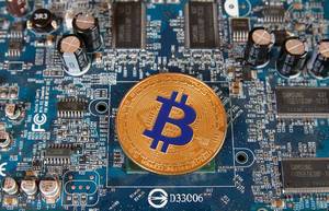 Golden Bitcoin on a computer mother board