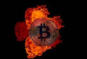Golden Bitcoin on fire over black background