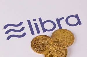 Golden coins with Libra cryptocurrency on white background