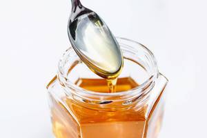 Golden Honey Pouring From The Spoon
