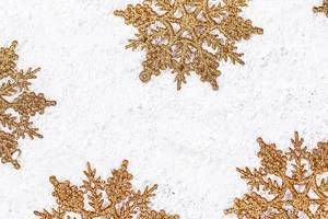 Golden snowflakes on snow background. Winter holidays concept