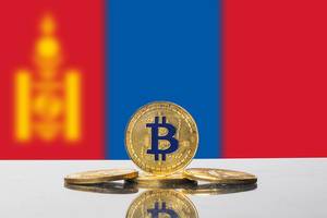 Goldene Münze der Kryptowährung Bitcoin mit der Flagge der Mongolei im Hintergrund