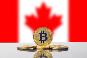 Goldener Bitcoin steht vor dem roten Ahornblatt auf der Flagge Kanadas im Hintergrund