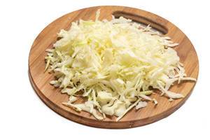 Grated cabbage salad on the round wooden board