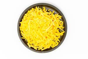 Grated Cheddar on a black plate with white background
