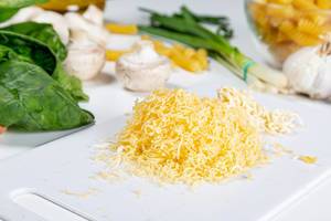 Grated cheese on a white kitchen Board