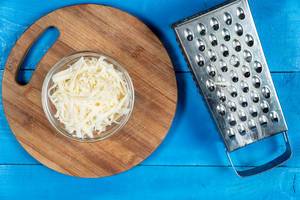 Grated Cheese on the wooden kitchen board (Flip 2020)