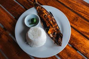 Grätenfreier, indonesischer Milchfisch, gegrillt und mit Reis auf einem weißen Teller serviert