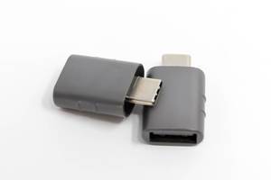 Grauer USB-Adapter von Syntech, für USB-C und USB-OTG auf einem weißen Tisch