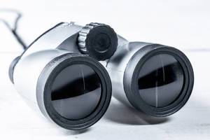 Gray binoculars close-up on white background