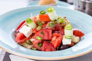 Greek salad with tomato, cucumber, dry onion, sun-dried tomato, feta cheese, capers and olive oil