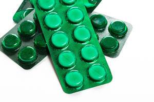 Green blisters with medical pills on a white background