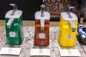 Green sweet relish, red tomato ketchup and yellow mustard in Heinz dispenser