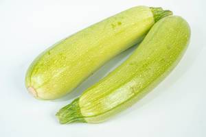 Green Zucchini above white background