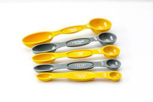 Grey and yellow measuring spoons in different sizes