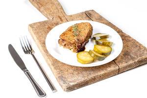 Grilled kebab with pickled cucumber on the kitchen board with knife and fork (Flip 2020)