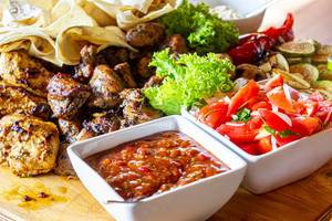 Grilled meat and vegetables with spicy sauce and fresh vegetables