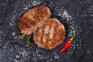 Grilled meat patties with salt and chili pepper. Top view (Flip 2019)