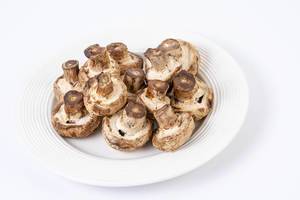 Grilled Mushrooms served on the plate isolated above white background (Flip 2019)