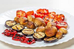Grilled tomatoes, peppers, mushrooms and eggplant on a white plate (Flip 2019)