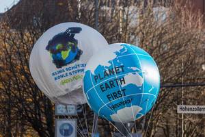 Große Luftballons als Erdkugeln mit Planet Earth First Aufschrift der Organisation Greenpeace