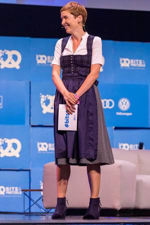 Gründermesse-Moderatorin Britta Weddeling im blauen Dirndl auf der Bits & Pretzels Bühne