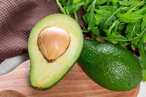 Grüne, reife Bio-Avocado und Rucolasalat