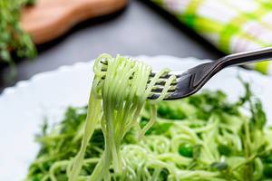Grüne Spaghetti auf einer Gabel